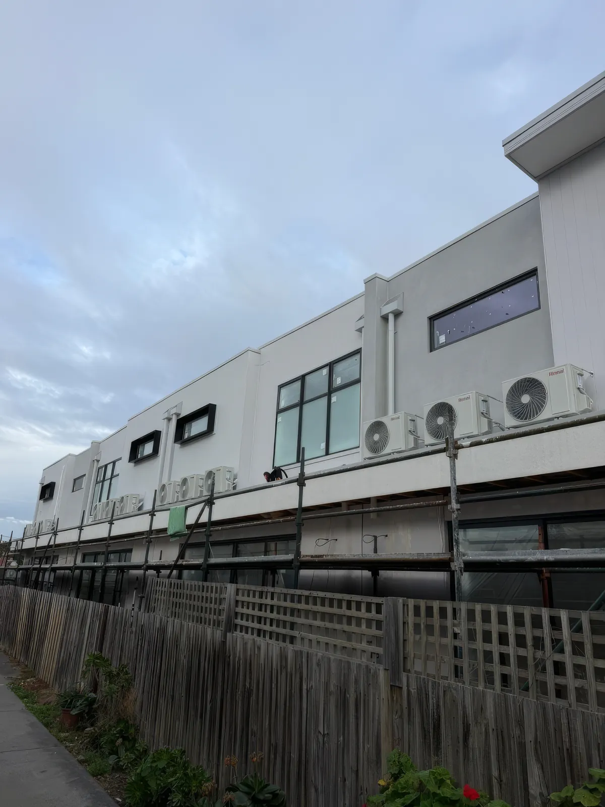 Condensers on an upper service ledge of a multi-storey commercial building in Brunswick